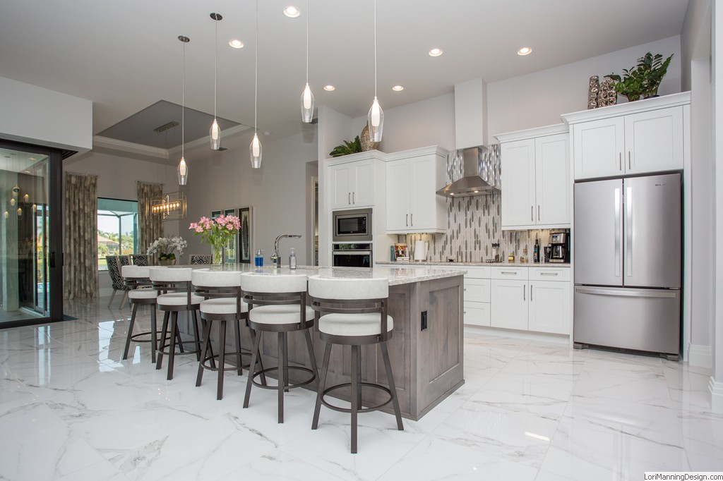 Kitchen features counter height stools, pendant lighting, modern style